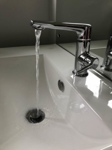 Bathroom tap with flowing water